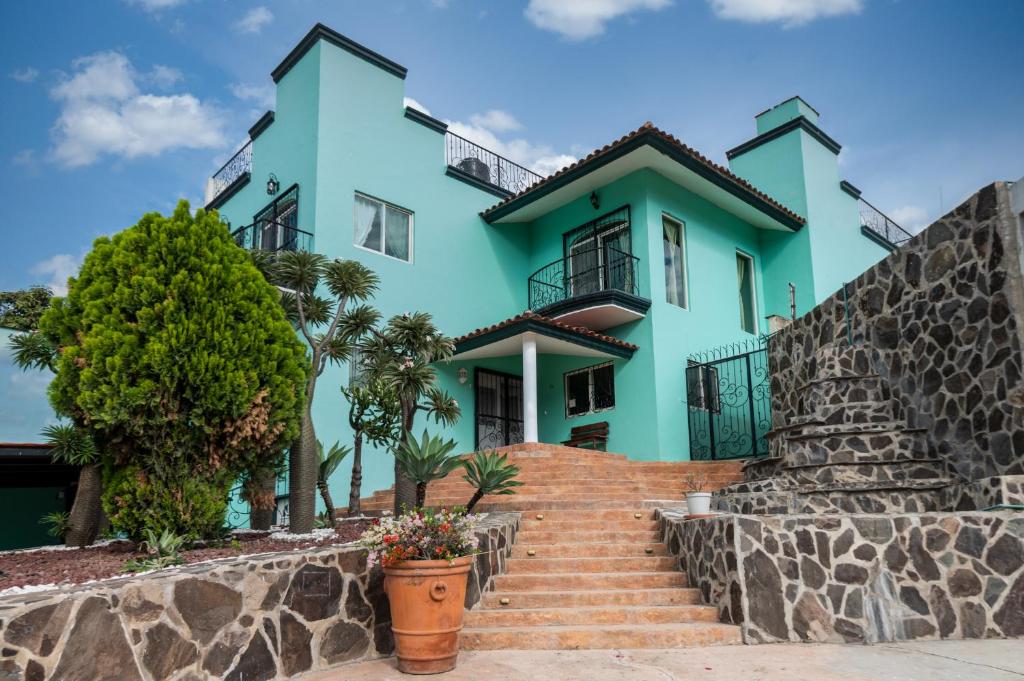 une maison bleue avec des escaliers en face de celle-ci dans l'établissement Sojourner’s Vista del Lago, à San Nicolás de Ibarra
