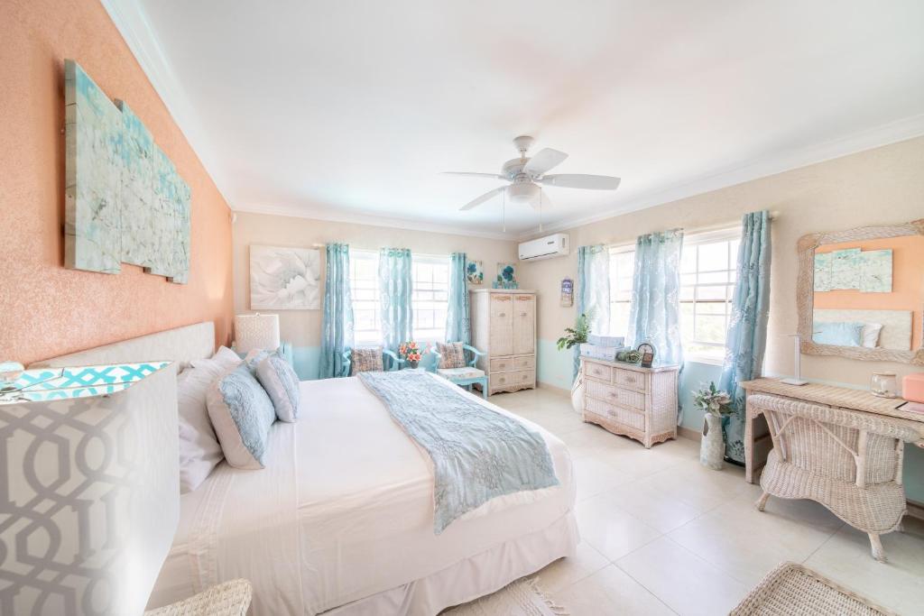a bedroom with a bed and a ceiling fan at Hidden Gem Barbados in Christ Church