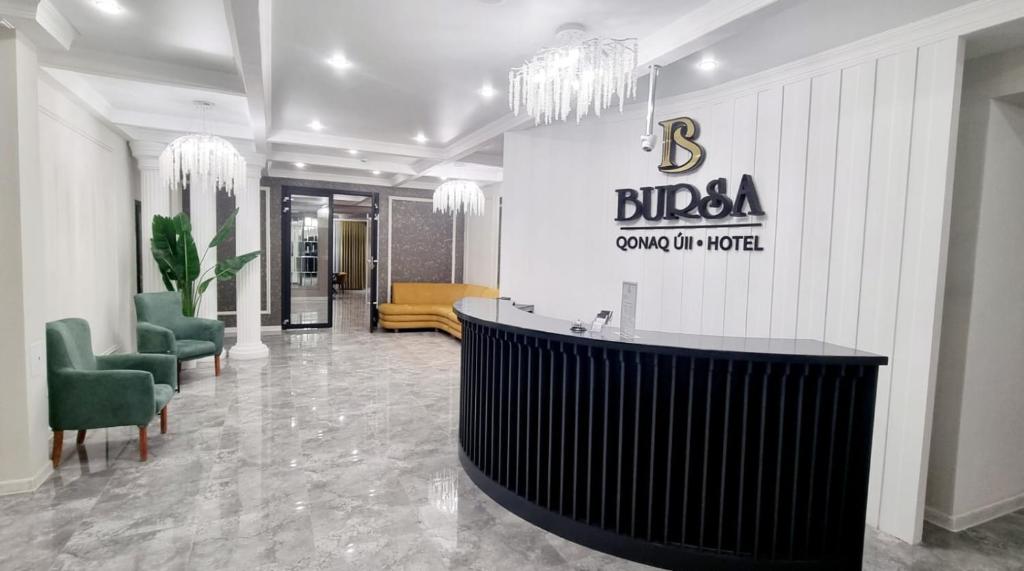a lobby of a hotel with a reception desk and chairs at BURSA in Taraz