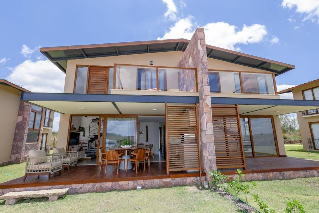 a house with a large deck with a table and chairs at Casa 19 da Vila Beija Flor in Mucugê