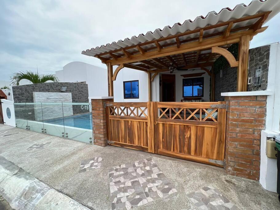 ein Haus mit einem Holztor und einem Zaun in der Unterkunft Casa con piscina Punta Carnero in Salinas