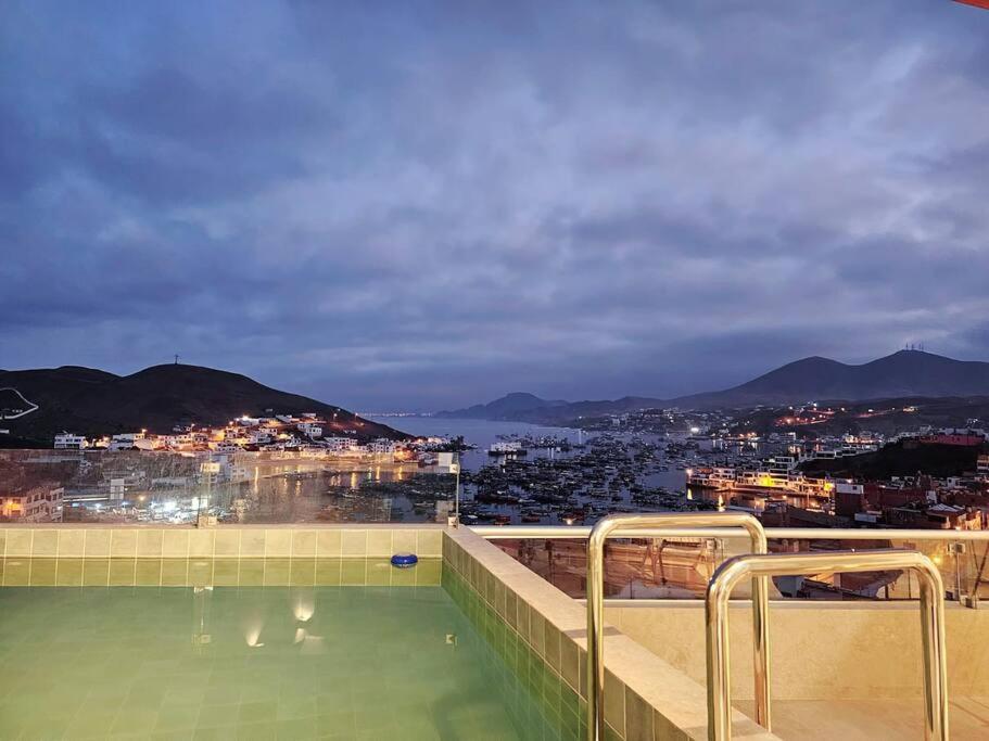 una piscina con vistas a la ciudad por la noche en Hermoso dúplex con gran vista!, en Pucusana