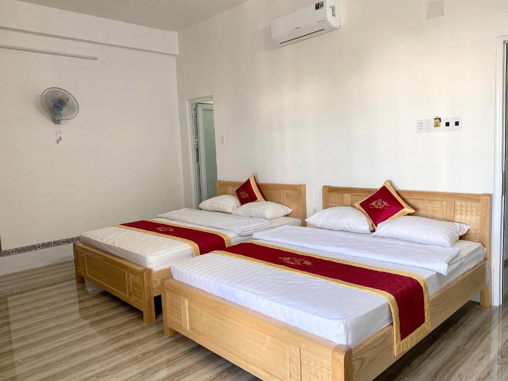 - 2 lits dans une chambre aux murs blancs dans l'établissement Khách Sạn Ngọc Quý, à Kinh Dinh