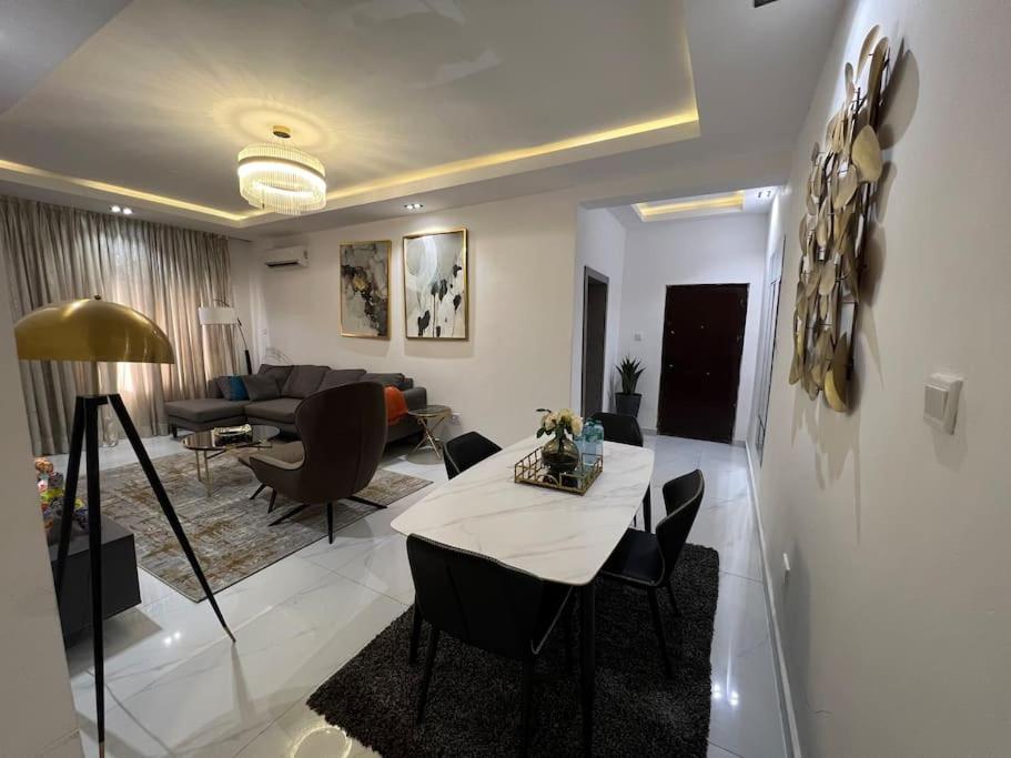 uma sala de estar com uma mesa e um sofá em Gorgeous 2 Bedroom with parking inside Banana Island, Ikoyi em Lagos
