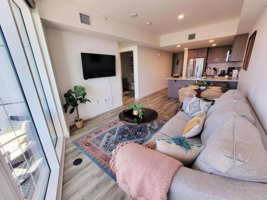 a living room with a large couch and a kitchen at Stunning 1bed Apartment Downtown 1 min to Petco Park Convention Center in San Diego