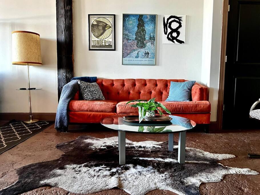 uma sala de estar com um sofá vermelho e uma mesa em 420 Friendly Downtown Loft KING suite FREE parking em Detroit