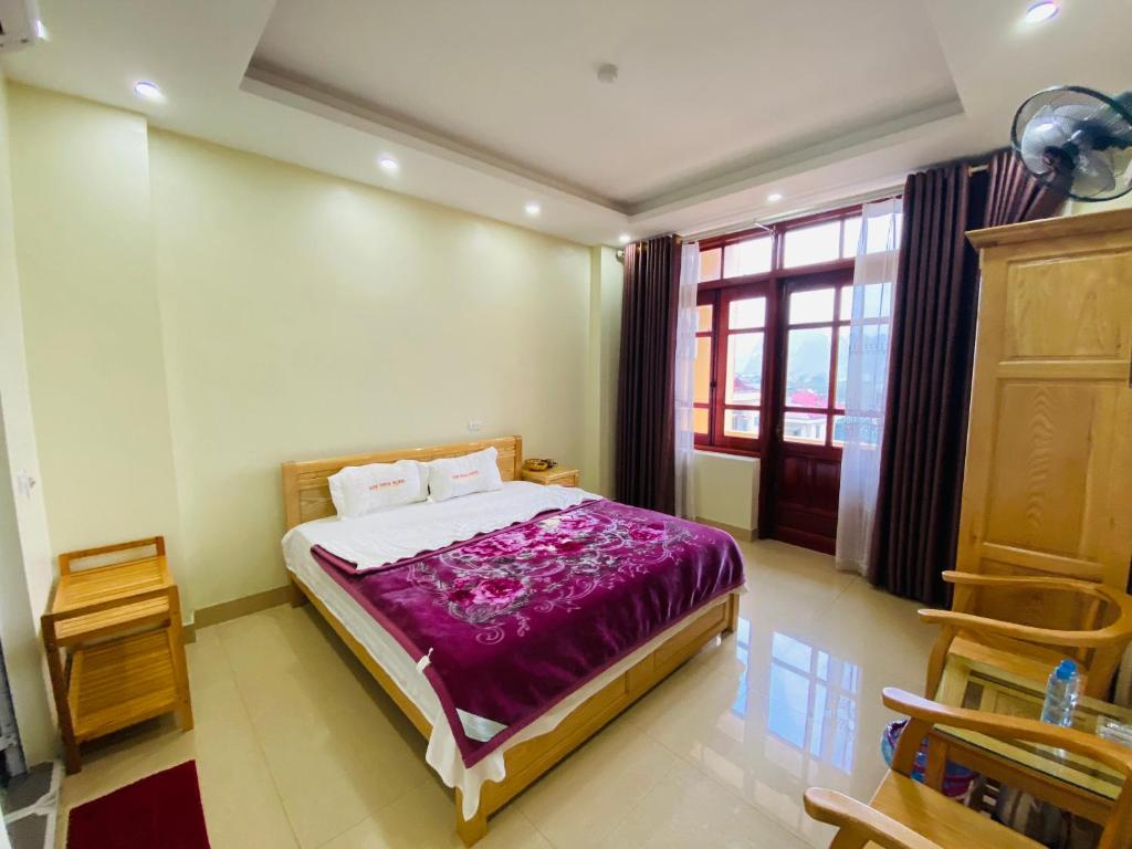 1 dormitorio con 1 cama con manta morada en Kim Thoa Hotel Trung Khanh, en Bản Piên