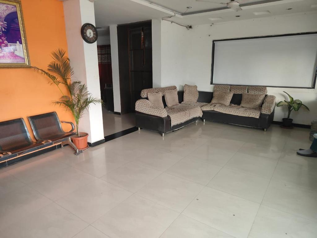 Habitación grande con 2 sofás y pantalla de proyección en Sai Amaravathi Residency, en Shirdi