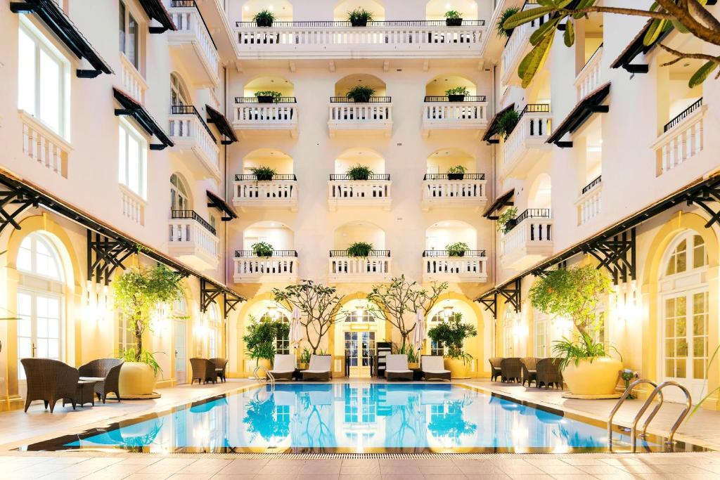 un vestíbulo de hotel con piscina y un edificio en Central Mansions Serviced Apartments en Phnom Penh