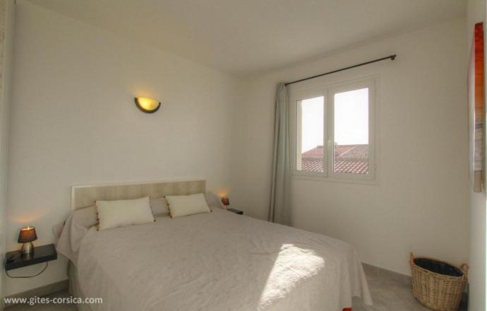 Habitación blanca con cama y ventana en Idéal logement Cargese 4 en Cargèse