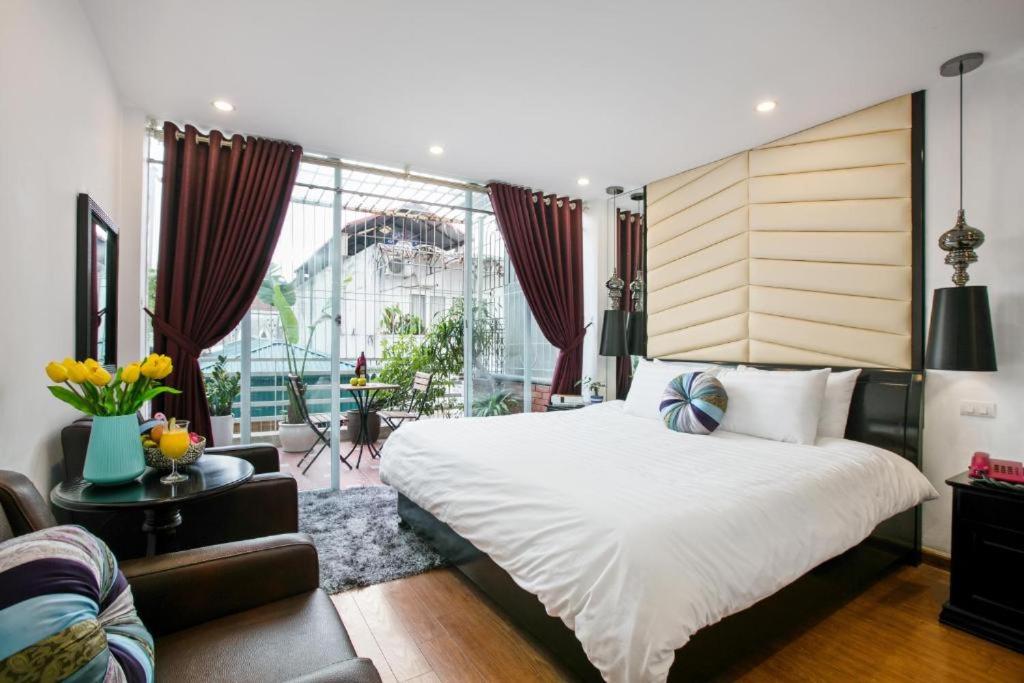a bedroom with a large bed and a large window at Splendid Holiday Hotel Spa in Hanoi