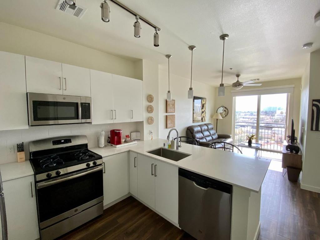 a kitchen with a sink and a stove top oven at Ely on Fremont in Las Vegas