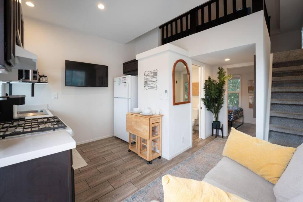 a kitchen and living room with a couch and a stove at Coastal Tiny House 2 Queen Beds low loft in San Luis Obispo