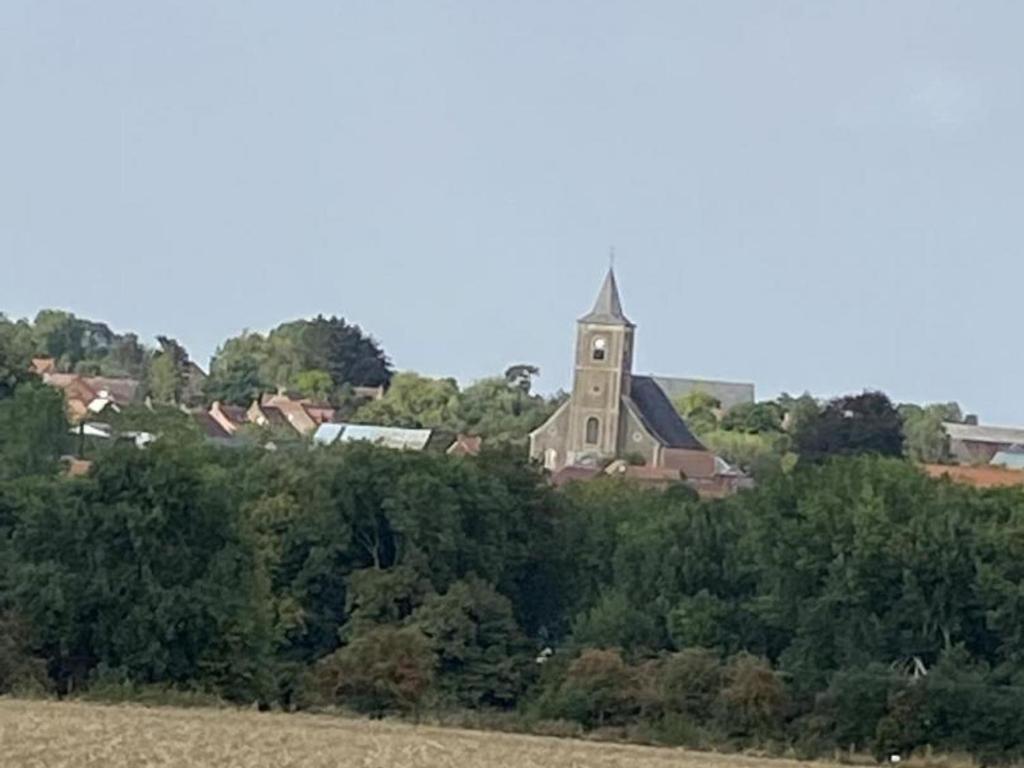 a church sitting on top of a hill with trees at Gîte Villers-Pol, 3 pièces, 4 personnes - FR-1-510-190 in Villers-Pol