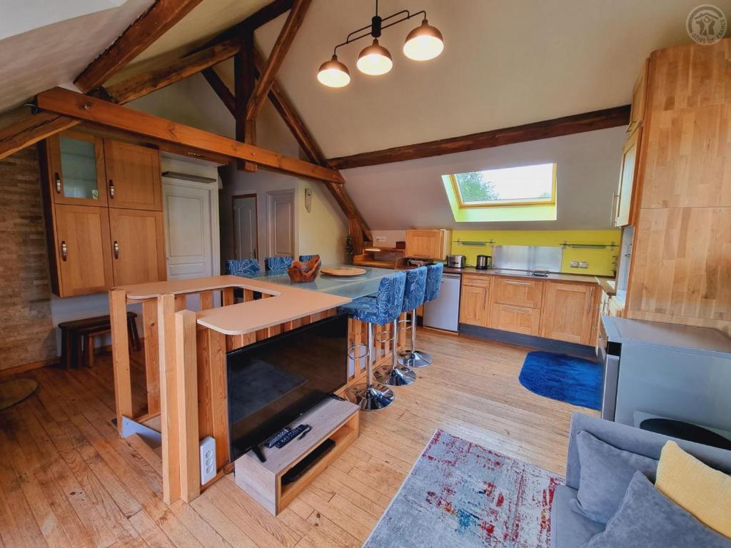 une grande cuisine avec des armoires en bois et des chaises bleues dans l'établissement Appartement tout équipé dans un cadre naturel, proche du Parc Avesnois et commodités, jusqu'à 5 pers. - FR-1-510-189, à Orsinval