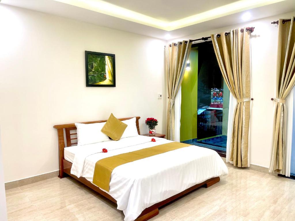 1 dormitorio con cama y ventana grande en King Kong Homestay, en Hoi An