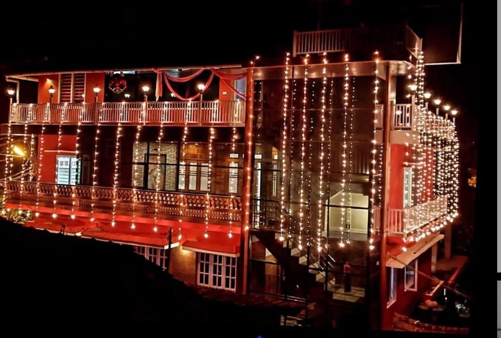 un edificio iluminado con luces de Navidad en él en Coorg Cu’s Homestay, en Madikeri