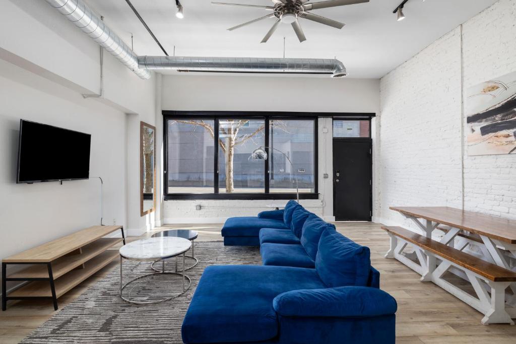 a living room with blue couches and a tv at Art District Loft - 4BD/2BA Downtown SGF in Springfield