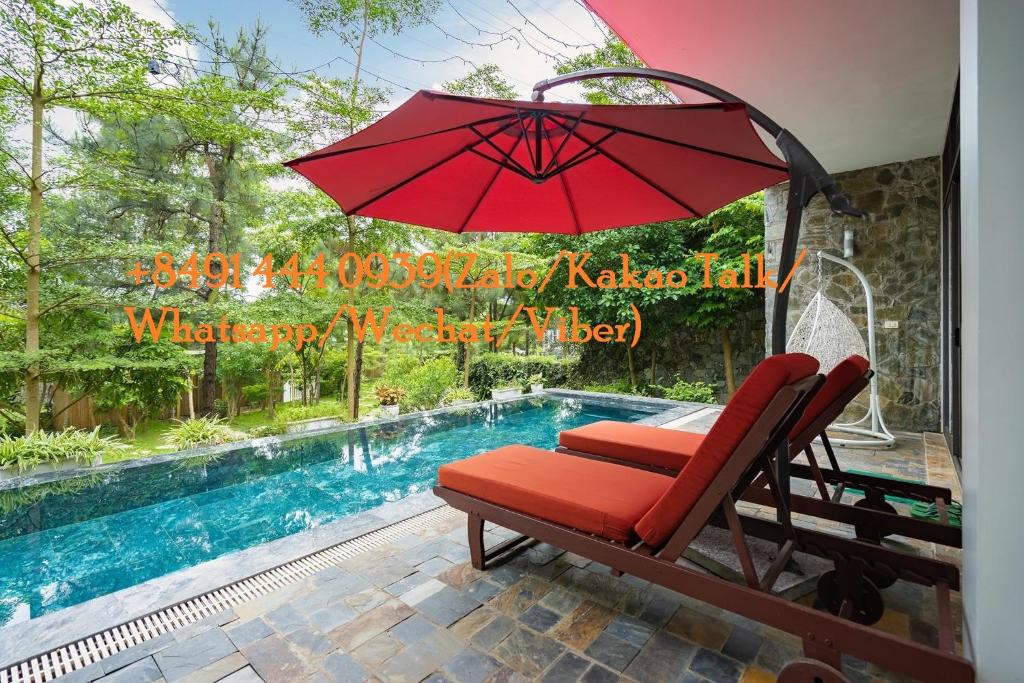 una sombrilla roja sentada junto a una piscina en Bách Thanh Villa C15 - FLAMINGO ĐẠI LẢI, en Phúc Yên