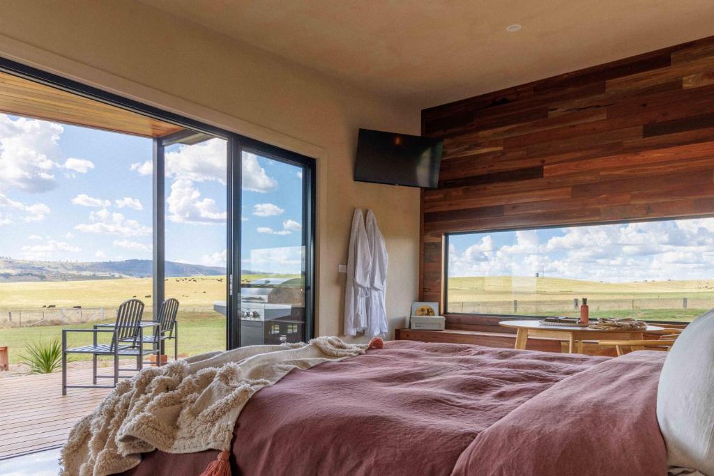 a bedroom with a large bed and a large window at Rest Private Escape at BoxGrove in Bathurst
