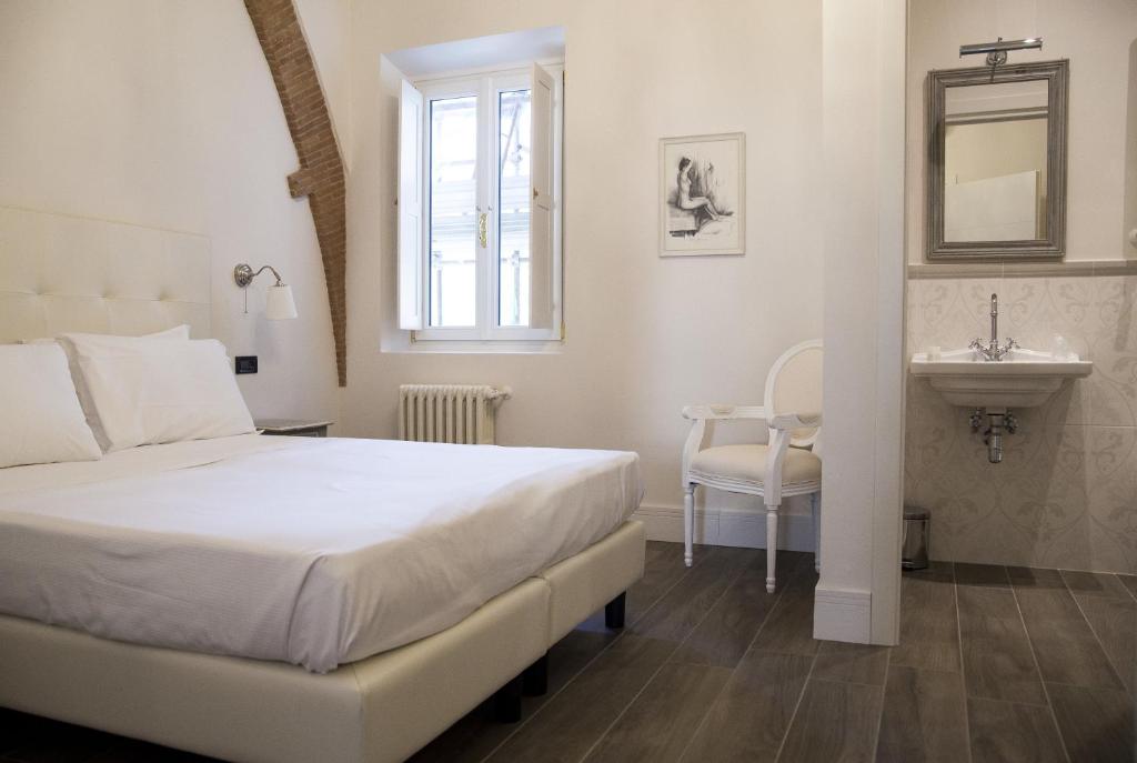 a white bedroom with a bed and a sink at Tornabuoni View in Florence