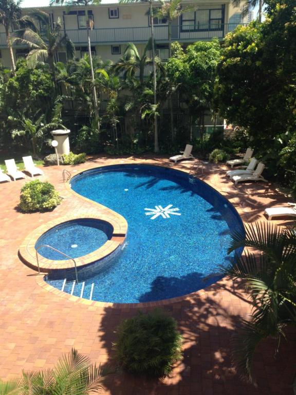 a large blue swimming pool with chairs and a building at Centrepoint Resort in Gold Coast