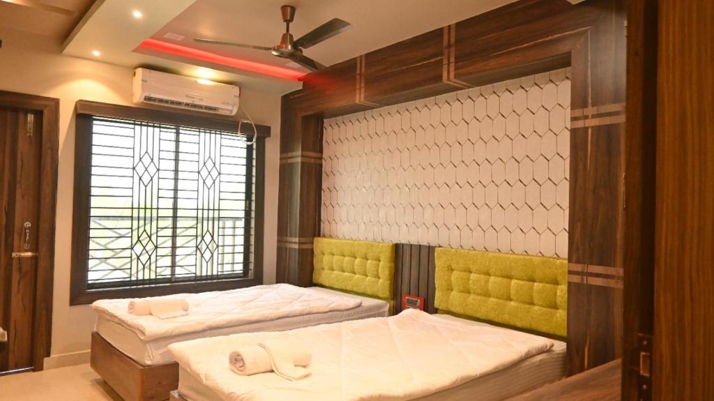 een kamer met 2 bedden en een raam bij Hotel Maisha International in Sonāmura