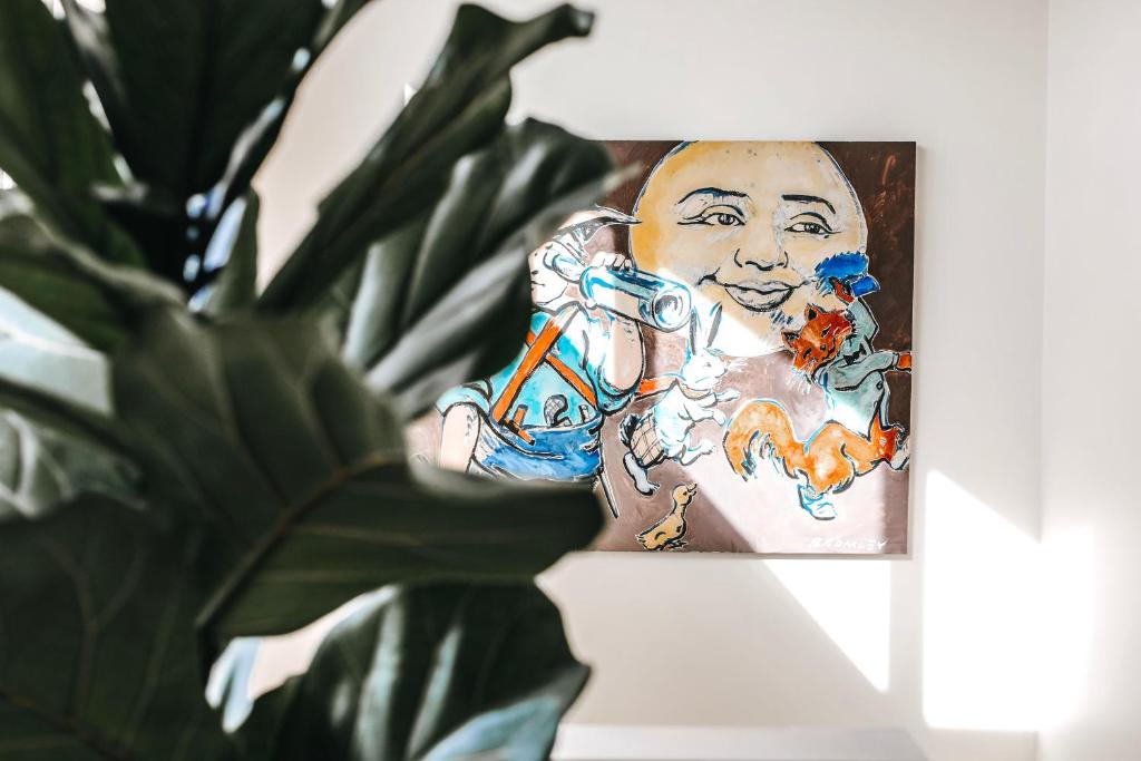 a painting of a man holding a toothbrush next to a plant at 12 Apostles Accommodation Anchors Beach House with sea views in Port Campbell