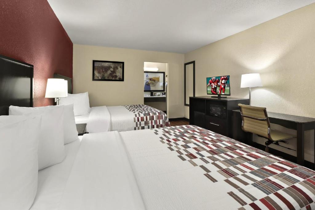 Red Roof Inn & Suites Cave City في كيف سيتي: غرفة فندقية بسريرين ومكتب
