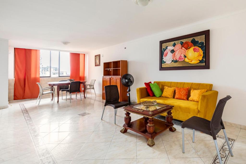 een woonkamer met een gele bank en een tafel bij Hermoso Apartamento Riomar in Barranquilla