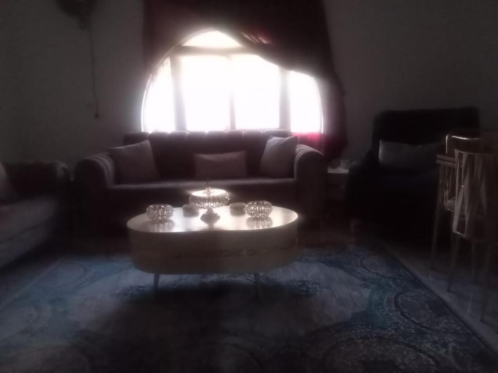 a living room with a couch and a coffee table at Khalda tawn in Rujm ash Sharāʼirah