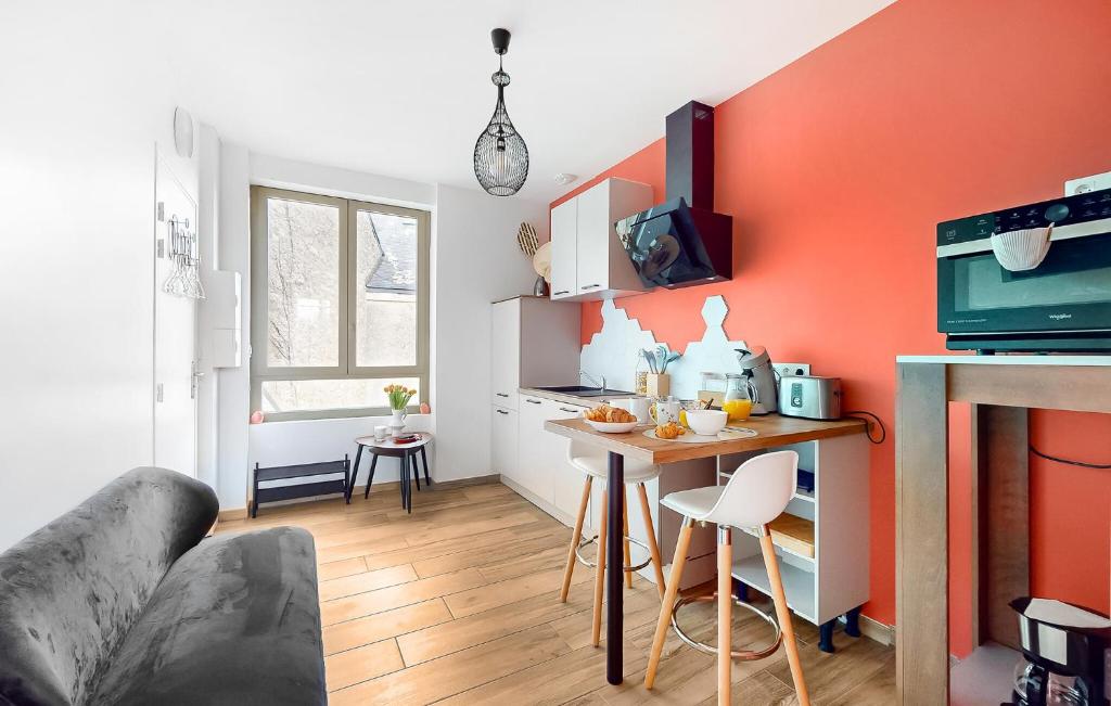 een woonkamer met een oranje accentmuur bij 1 Bedroom Cozy Apartment In Melrand in Melrand