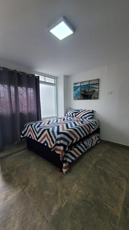 a bedroom with a bed and a window at Sanbar House in San Bartolo