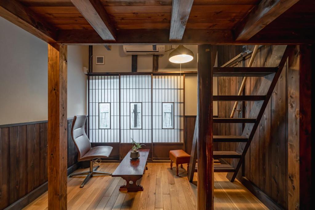 a room with a staircase and a chair and a table at すずめや築地 in Tokyo