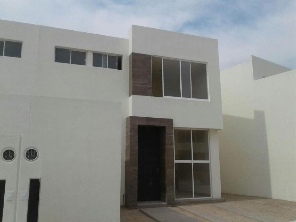 un edificio blanco con una puerta y un cielo en Ronda, en Aguascalientes