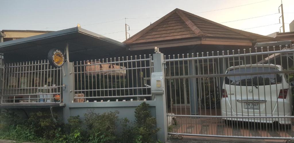 a house with a fence with a car in it at Pakin house in Ban Nua Khlong