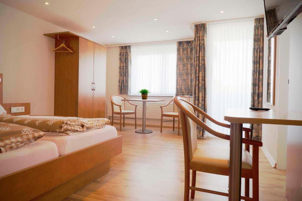 sypialnia z łóżkiem, stołem i krzesłami w obiekcie Apartment Deichstraße w mieście Bremerhaven