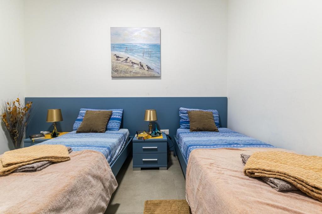 Un dormitorio con dos camas y un cuadro en la pared. en Brand New Apartment 3 Bdr 2 Bth Bugibba B8, en St Paul's Bay