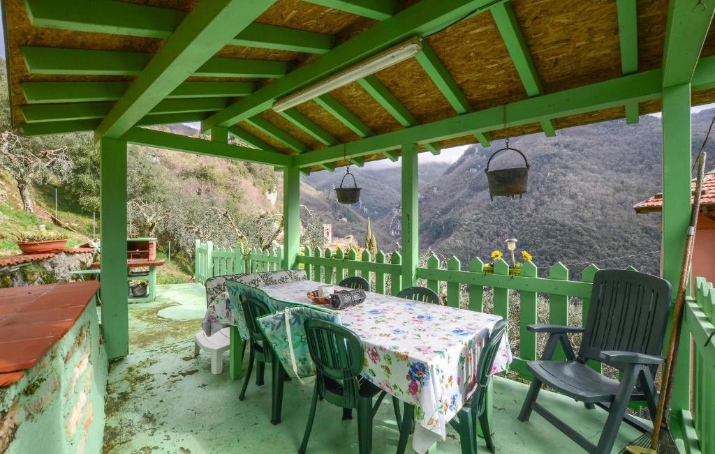 a green porch with a table and chairs with a view at Amazing Home In Camaiore With Wi-fi in Camaiore