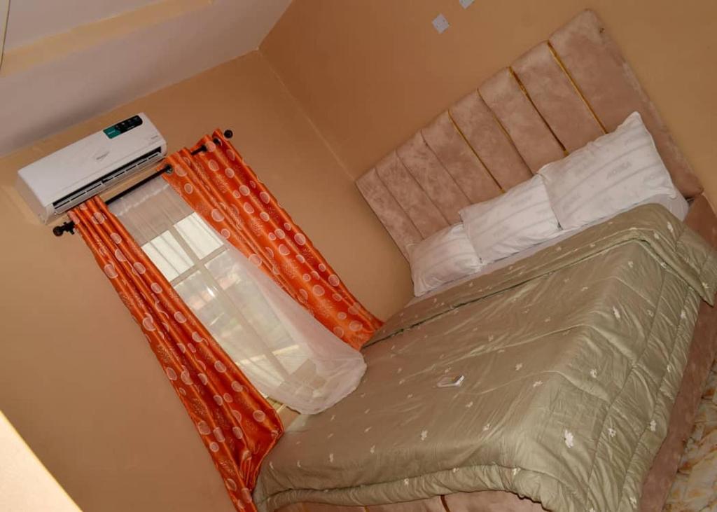 a small bedroom with a bed with avertisement at T'S PLACE APARTMENT in Abeokuta