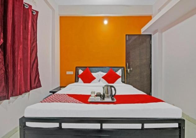 a bedroom with a bed with red and orange walls at KHUSH EXECUTIVE in Pune