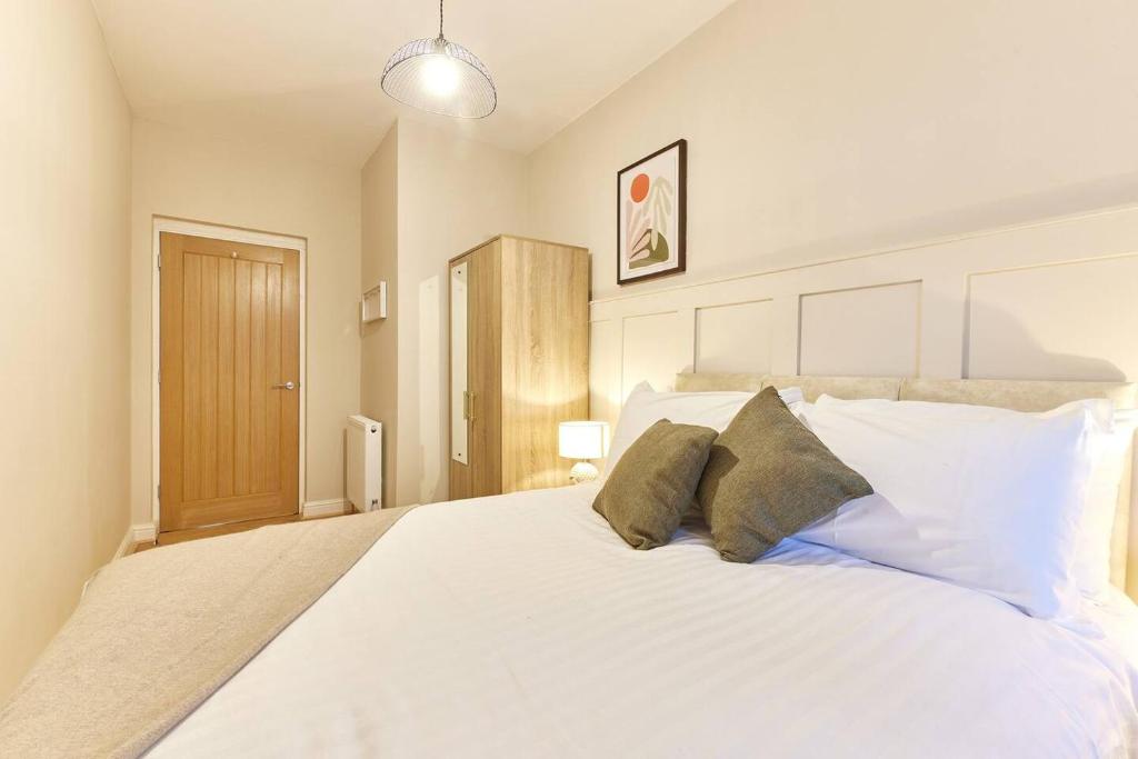 una camera da letto con un grande letto bianco con due cuscini di Modern Luxury 2-bedroom Oasis In Heart Of Whitley a Whitley Bay