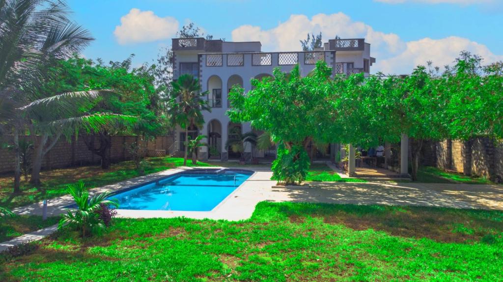 a house with a swimming pool and trees at Amani House in Kilifi