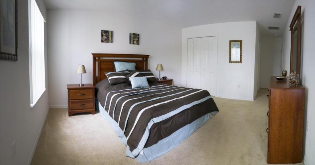 een slaapkamer met een groot bed en 2 nachtkastjes bij Five-Bedroom Pool Home Davenport in Davenport