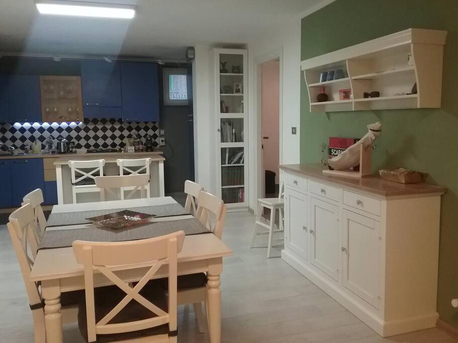 uma cozinha com uma mesa e uma mesa e cadeiras em Appartamento Super Confortevole em Gaglianico