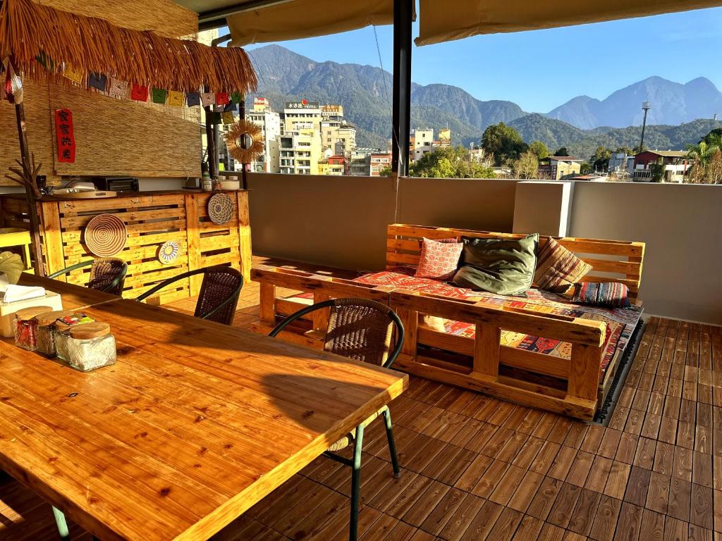 a patio with tables and a couch on a balcony at Dreamy Nomads Hostel日月潭背包客 in Yuchi