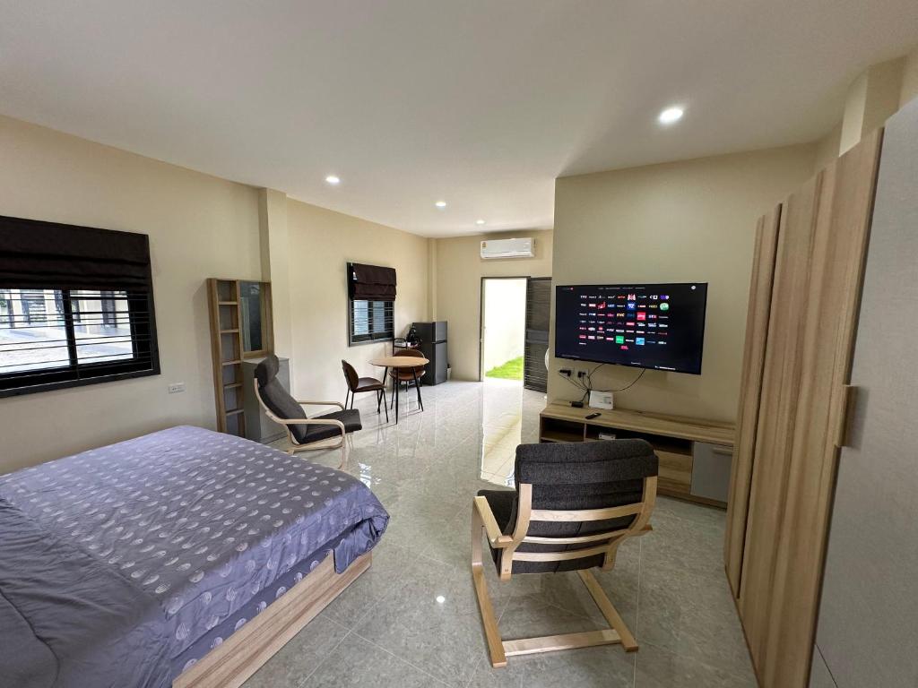 1 dormitorio con 1 cama y TV de pantalla plana en Vergers de Nil les lauriers 