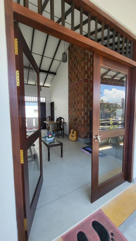 a living room with a door and a brick wall at BB GUESTHOUSE in Ambalangoda