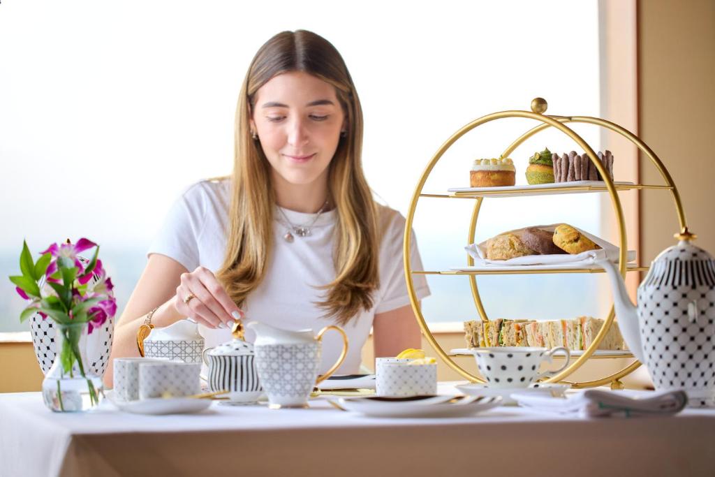 A styled afternoon-tea setting with pastries, sandwiches, and porcelain tea service.