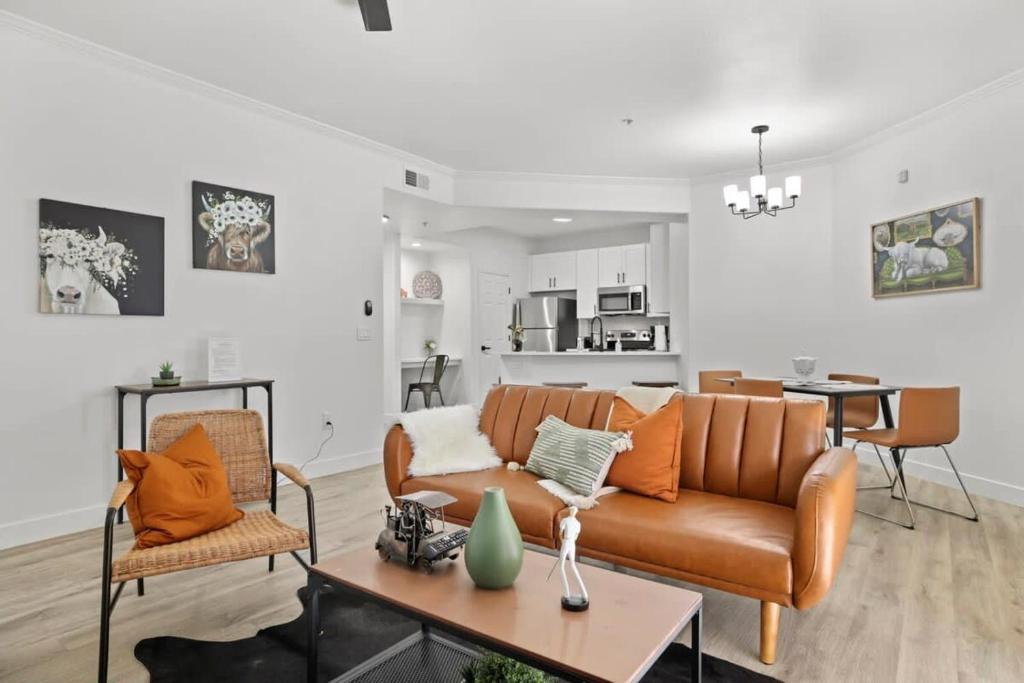 uma sala de estar com um sofá e uma mesa em Champion's CozySuite walk to the stadium with pool! em Glendale